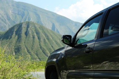 Black car near beautiful mountains and plants outdoors