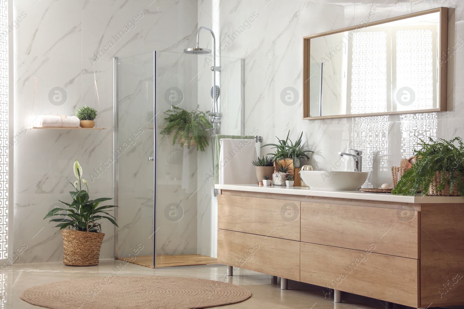 Photo of Stylish bathroom interior with countertop, shower stall and houseplants. Design idea