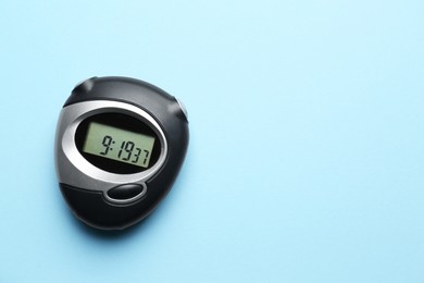 Digital timer on light blue background, top view. Space for text