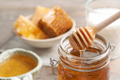 Photo of Honey pouring from dipper into jar, closeup