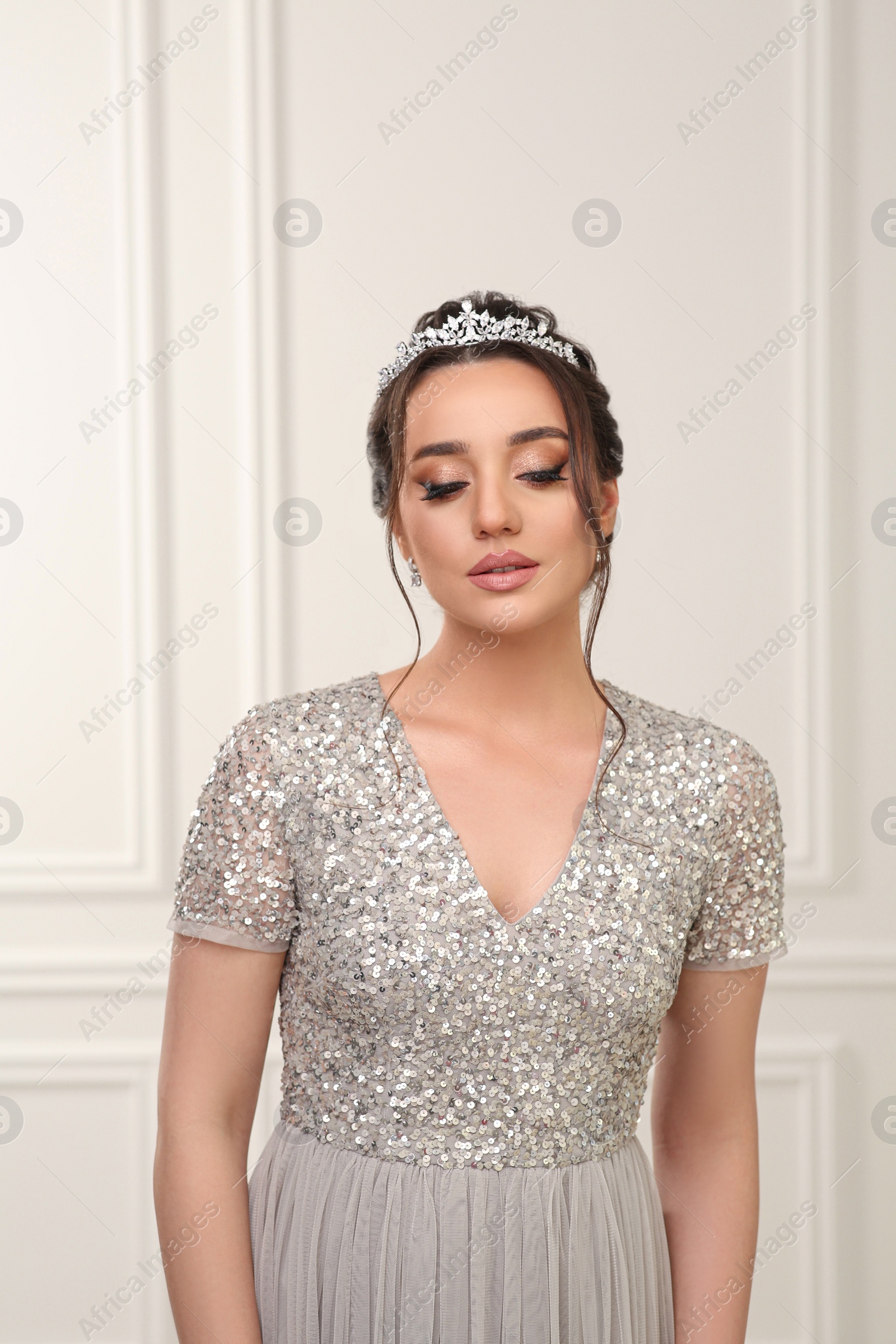 Photo of Beautiful young woman wearing luxurious tiara indoors