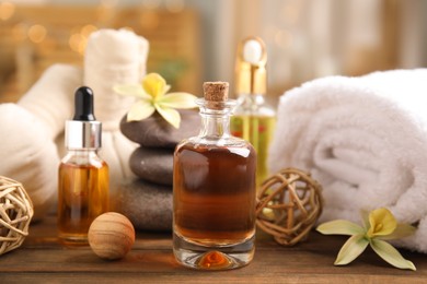 Beautiful spa composition with essential oil on wooden table against blurred lights