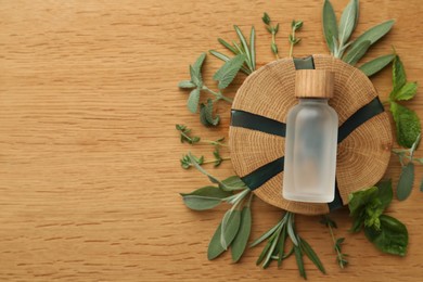Photo of Flat lay composition with bottle of essential oil and fresh herbs, space for text
