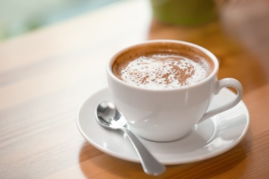 Cup of aromatic coffee on wooden table