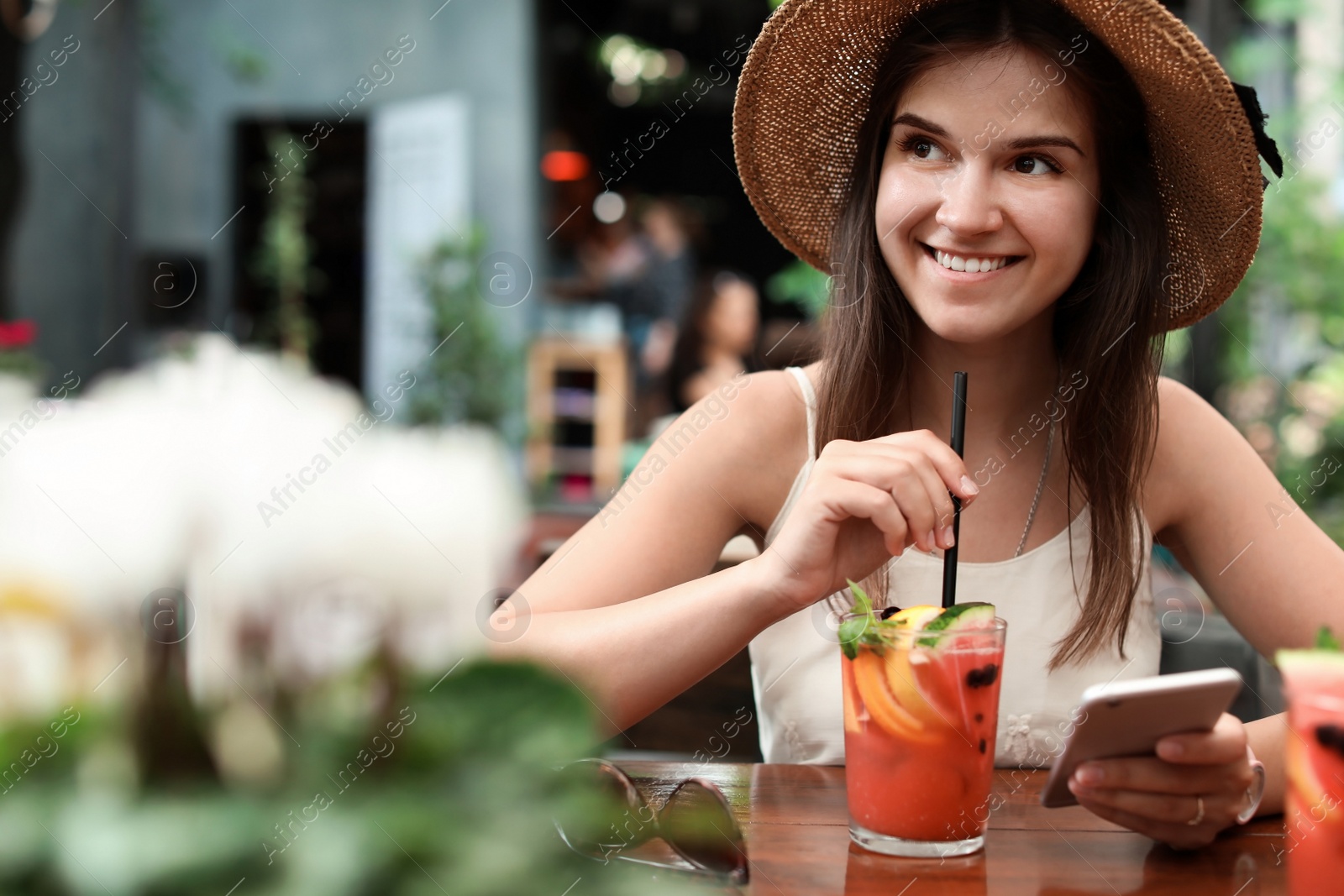 Photo of Woman with glass of tasty lemonade at table in cafe