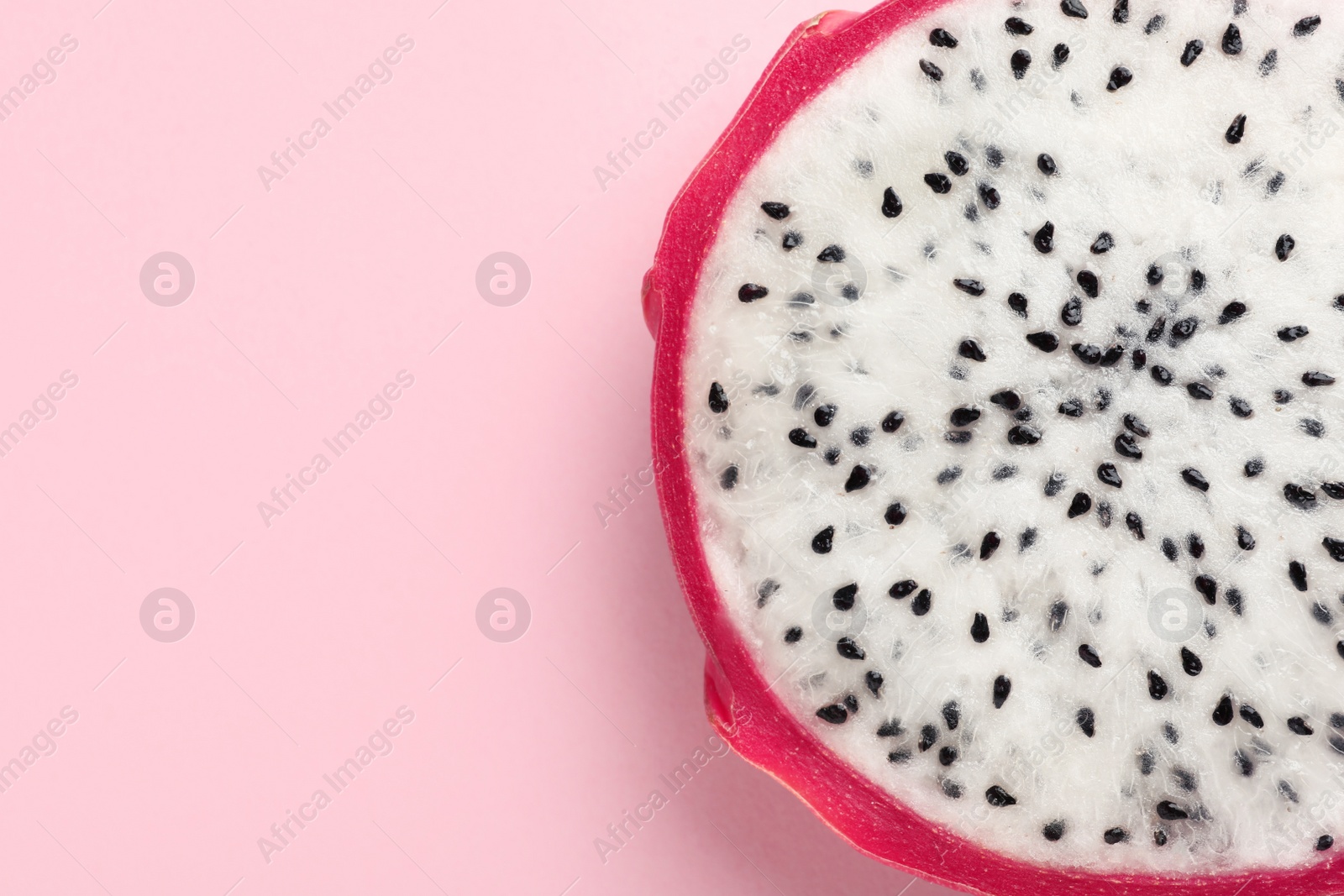 Photo of Delicious cut dragon fruit (pitahaya) on pink background, closeup. Space for text