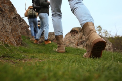 Group of people climbing up mountains, focus on hiking boots