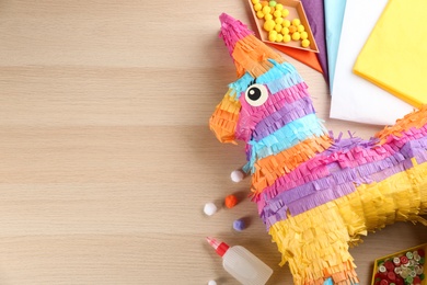 Photo of Flat lay composition with cardboard donkey on wooden table, space for text. Pinata diy