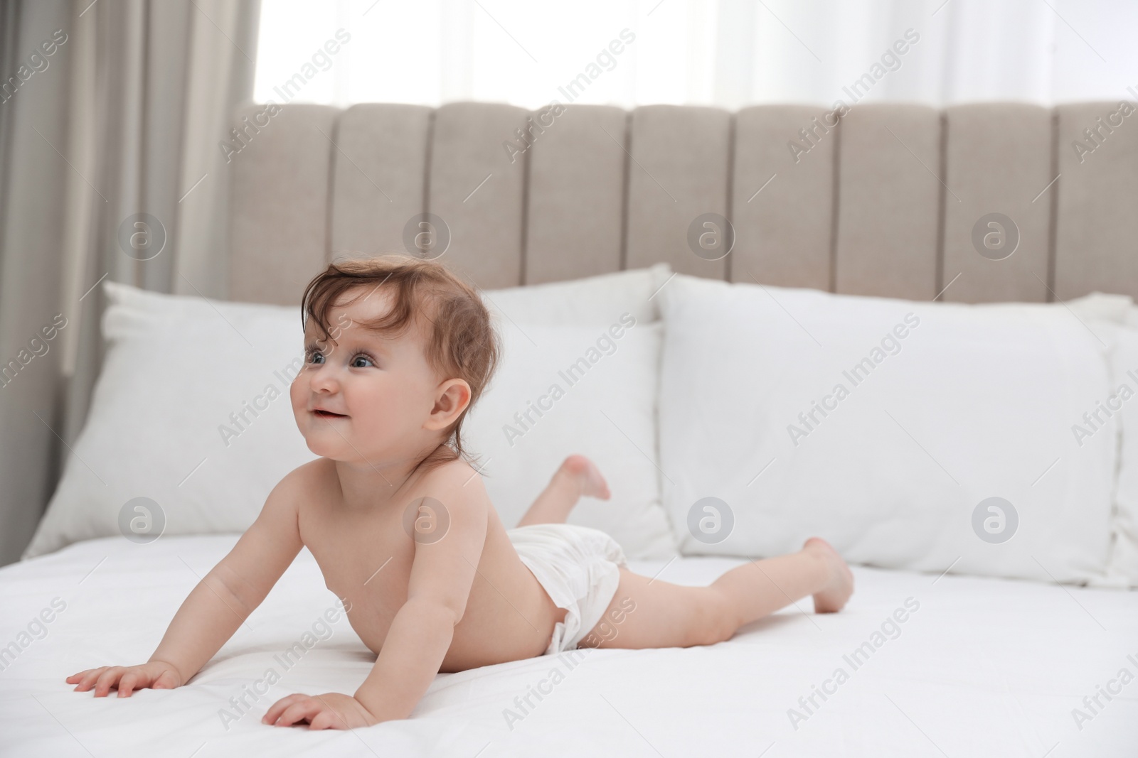 Photo of Cute little baby in diaper on bed