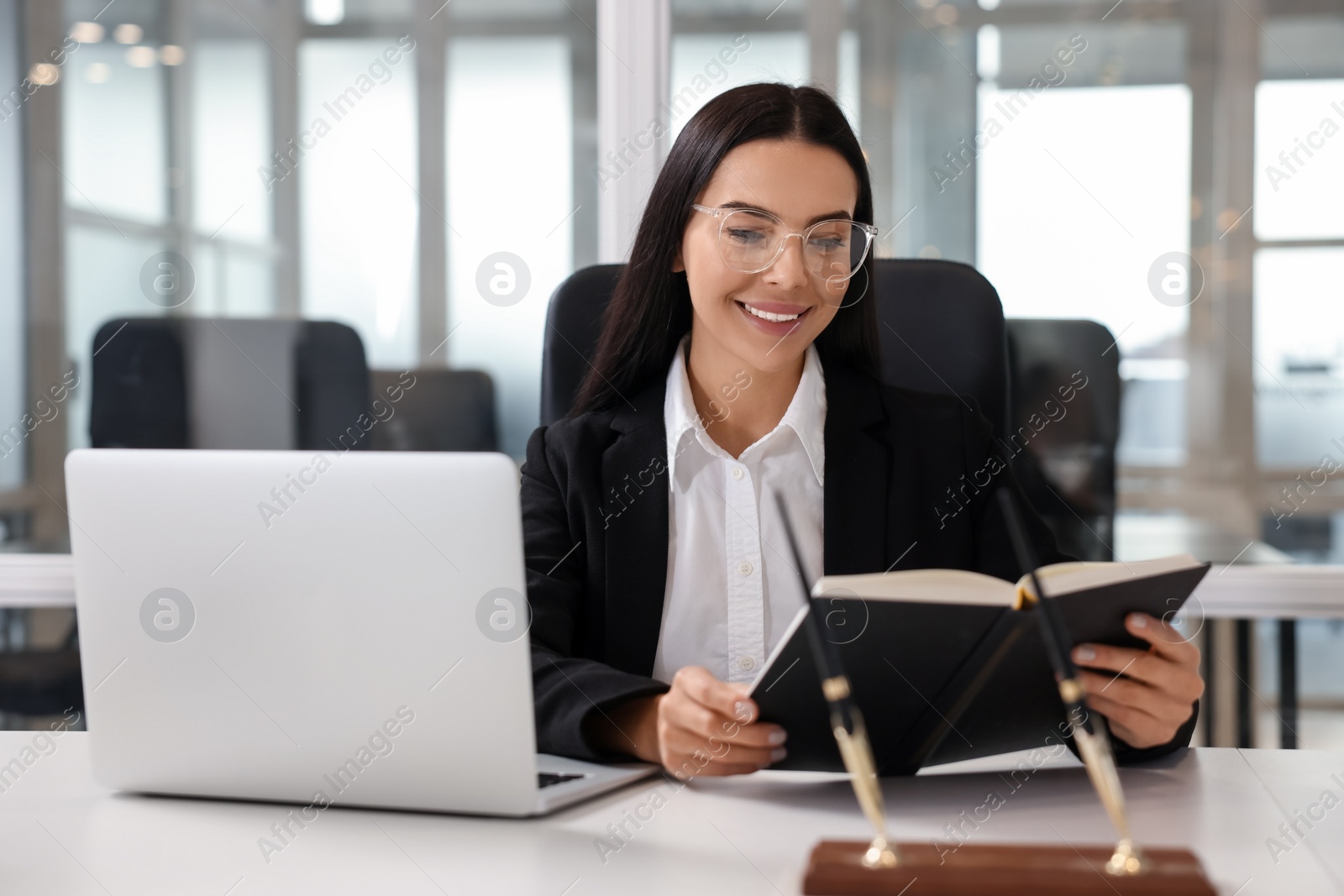 Photo of Smiling lawyer working at table in office