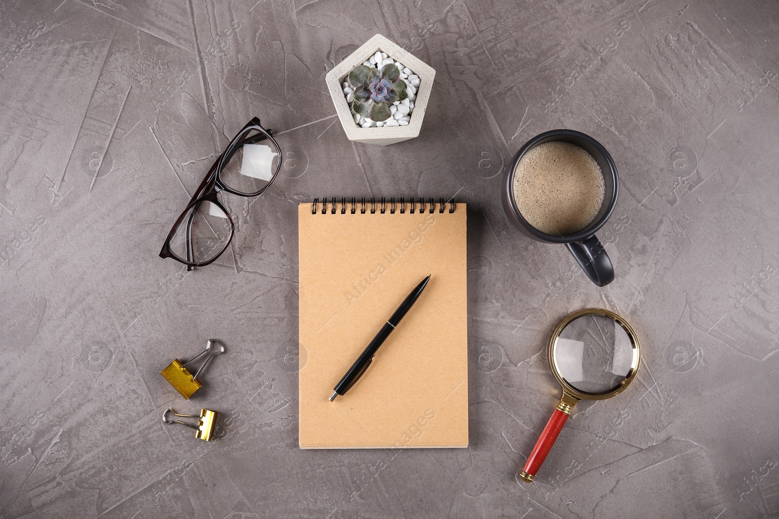 Photo of Flat lay composition with office stationery and cup of coffee on grey stone surface