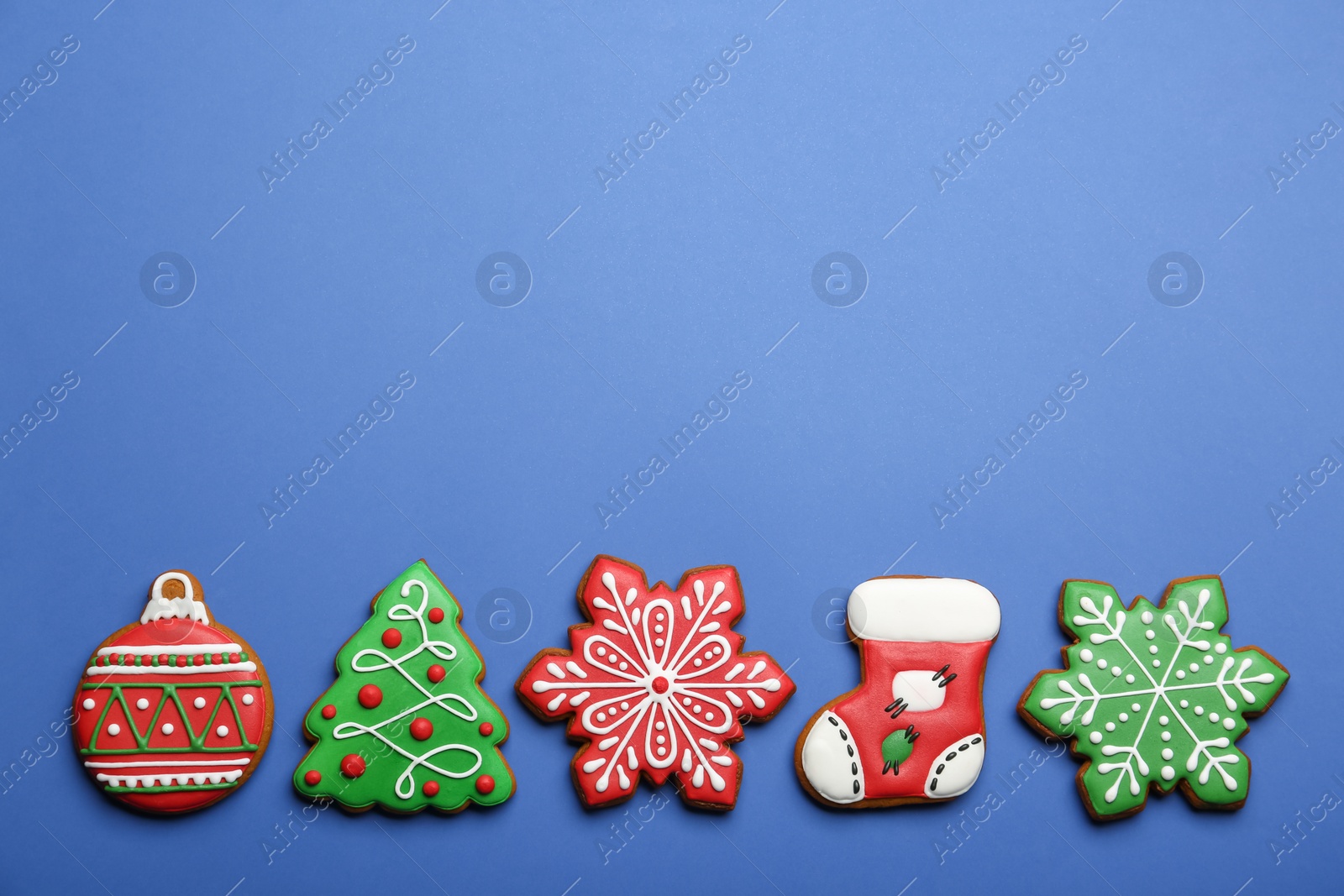 Photo of Different tasty Christmas cookies on blue background, flat lay. Space for text