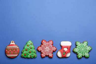 Different tasty Christmas cookies on blue background, flat lay. Space for text