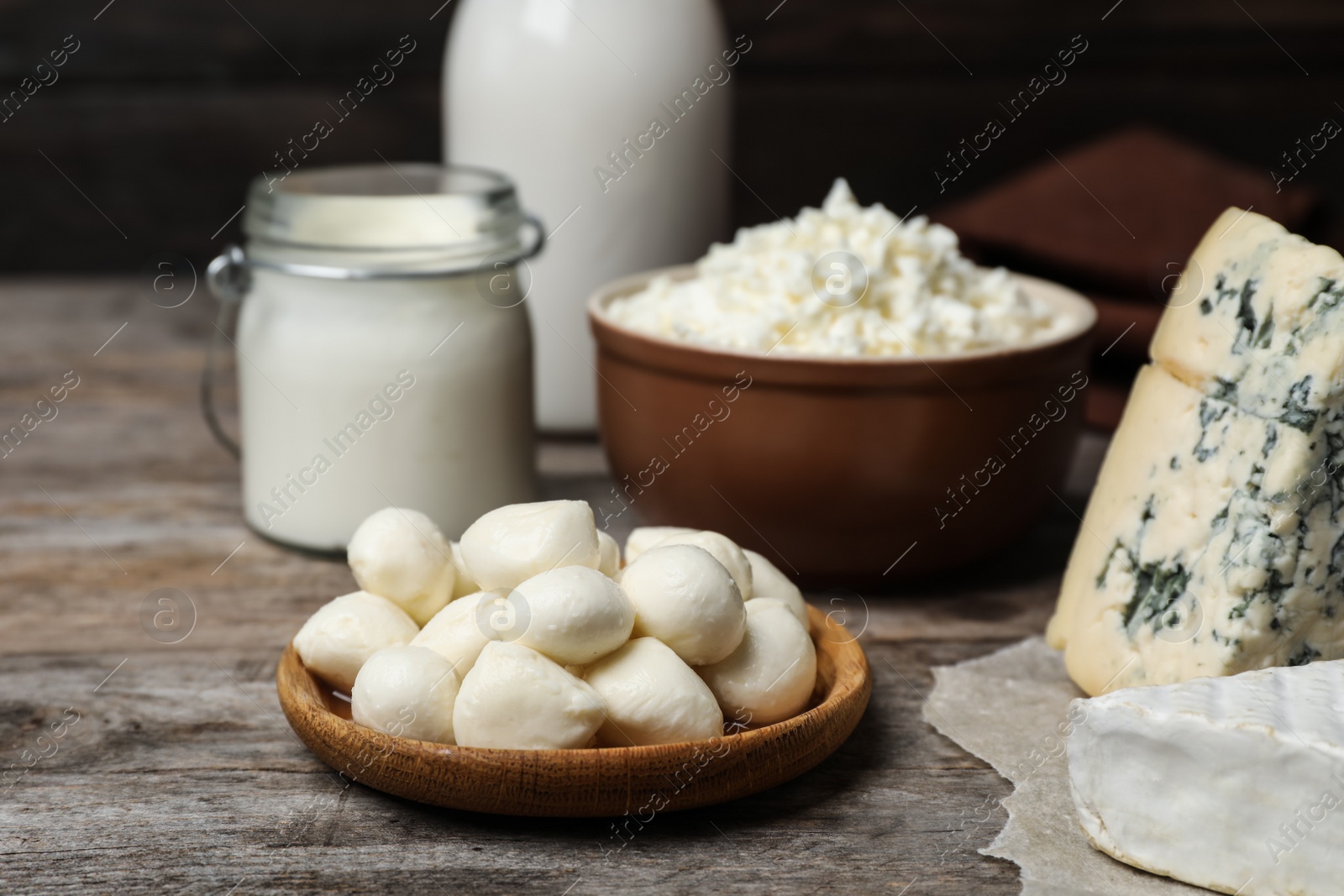 Photo of Plate with fresh mozzarella balls on wooden table. Dairy products