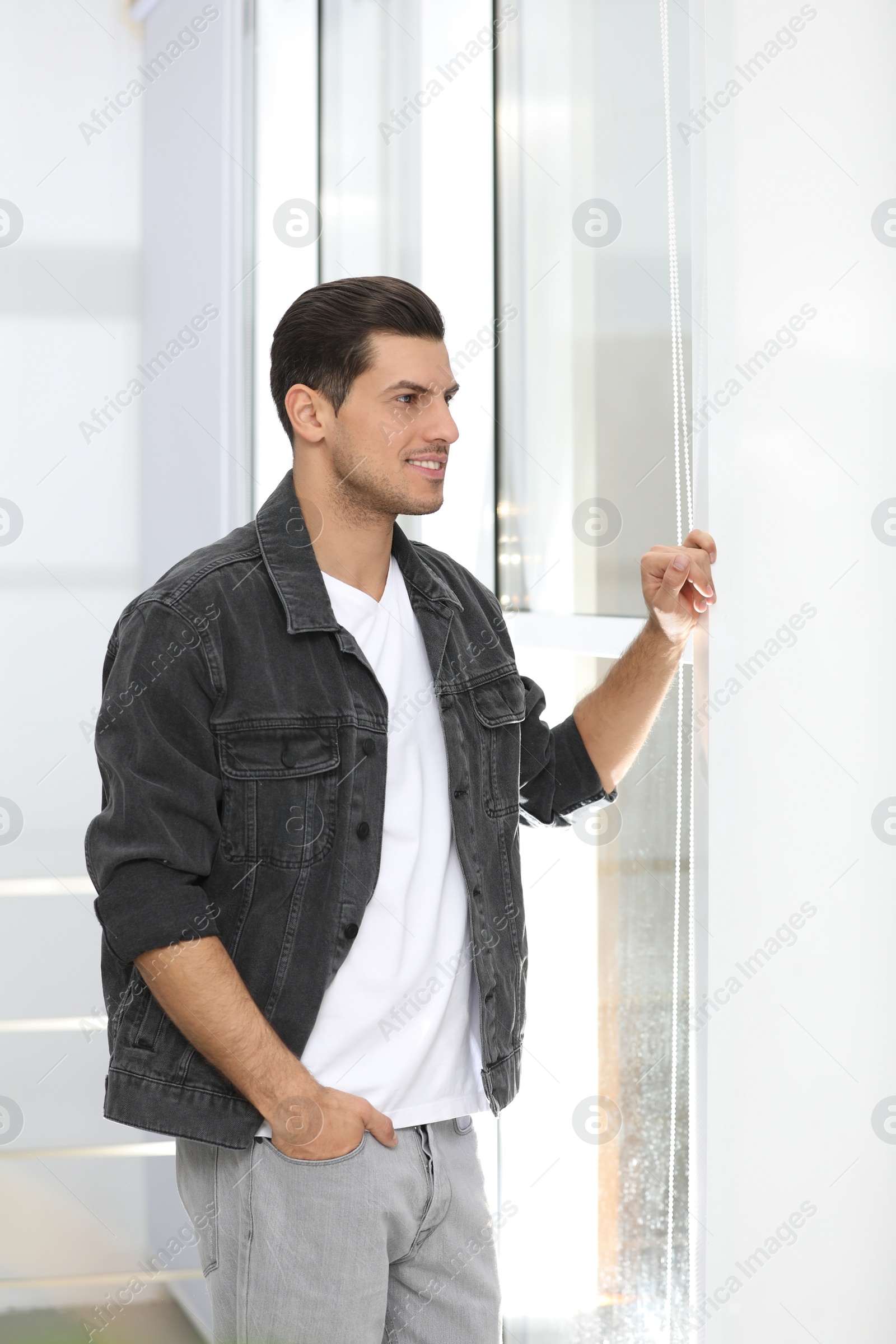 Photo of Handsome man wearing casual outfit near window at home