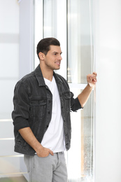 Handsome man wearing casual outfit near window at home