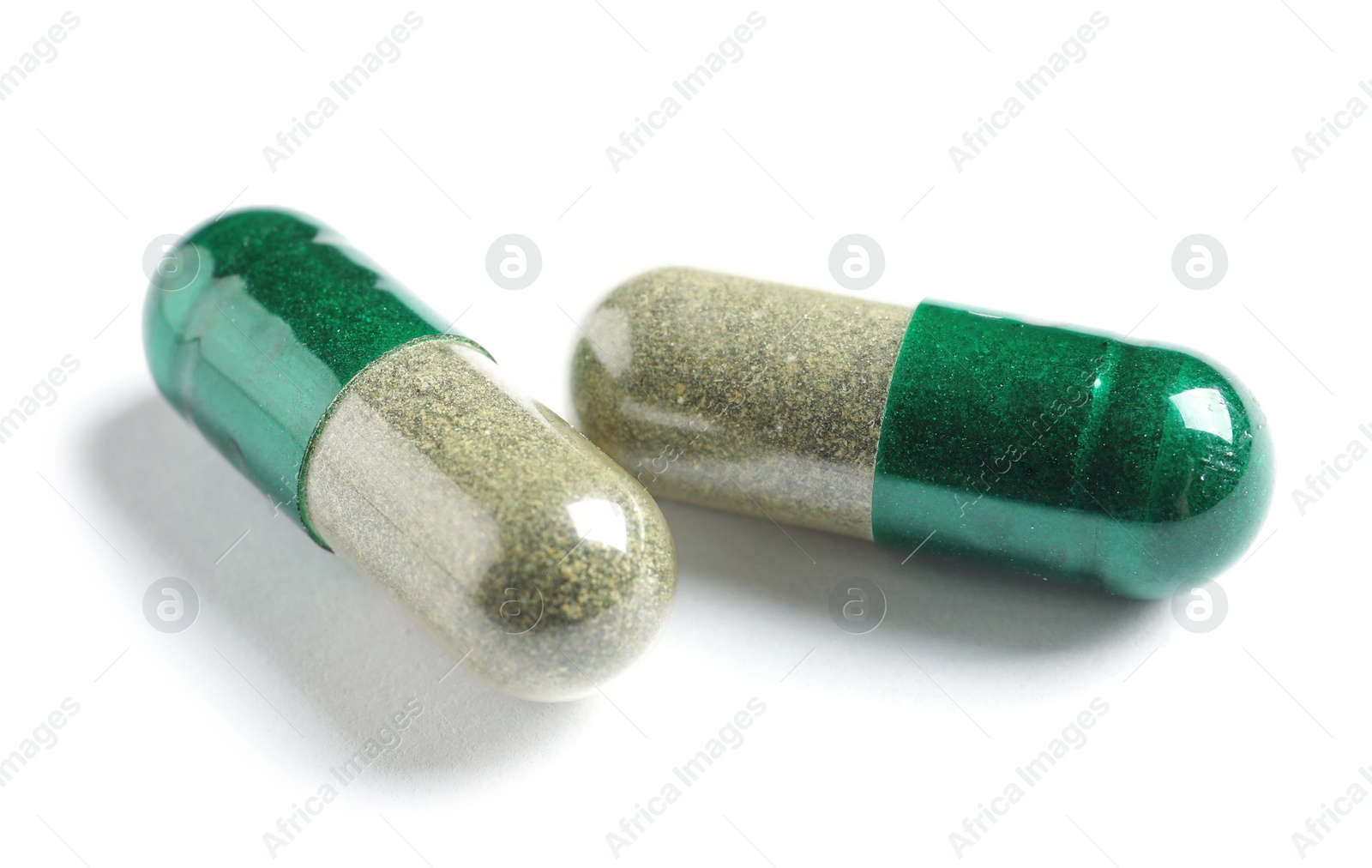 Photo of Green spirulina capsules on white background. Alternative medicine