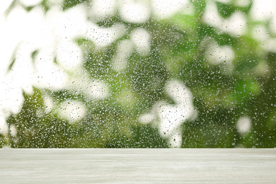 White wooden table near window on rainy day