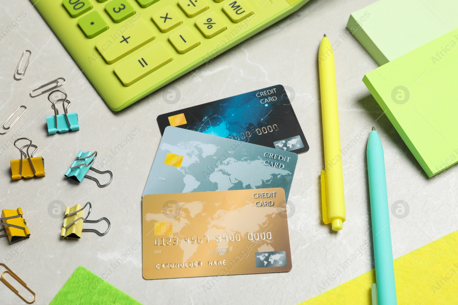 Photo of Composition with credit cards, calculator and stationery on light grey marble background