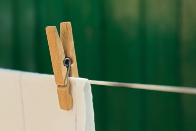 Washing line with clean laundry and clothespin outdoors, closeup