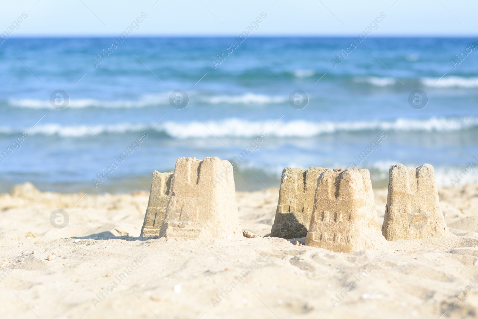 Photo of Beautiful sand castles on beach near sea