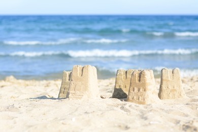 Photo of Beautiful sand castles on beach near sea