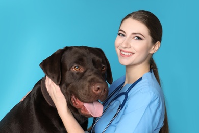 Photo of Veterinarian doc with dog on color background