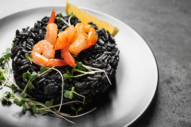 Delicious black risotto with shrimps on grey table, closeup