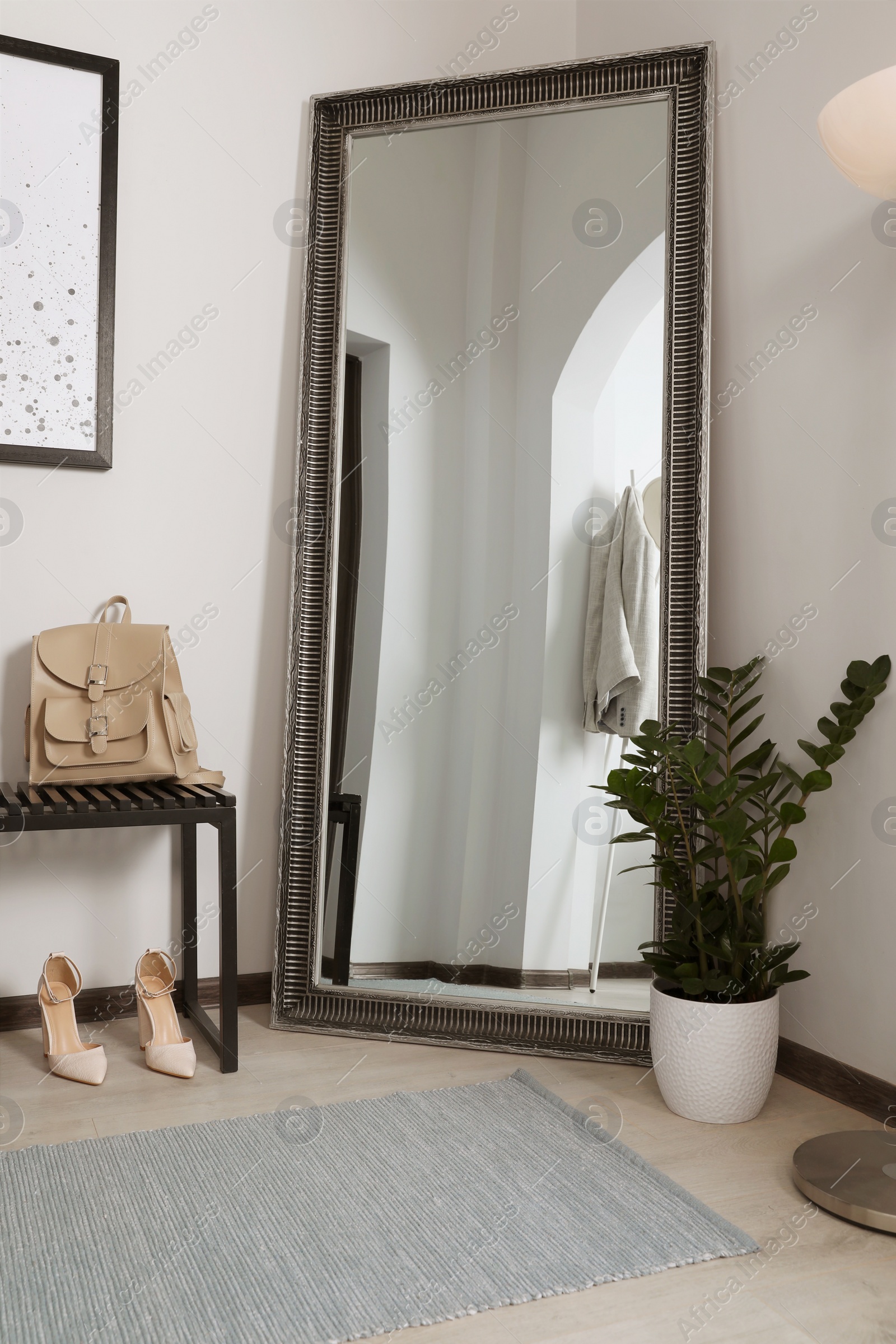 Photo of Modern hallway interior with large mirror and houseplant