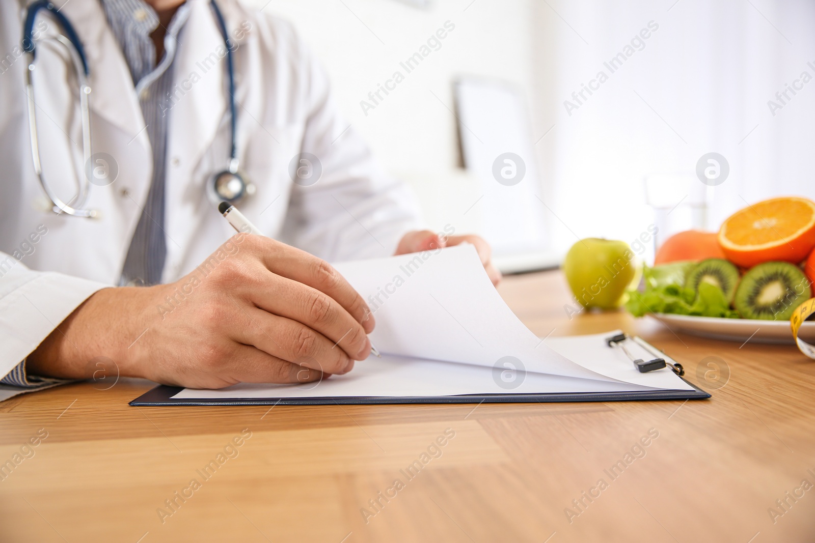 Photo of Nutritionist working at desk in office, closeup