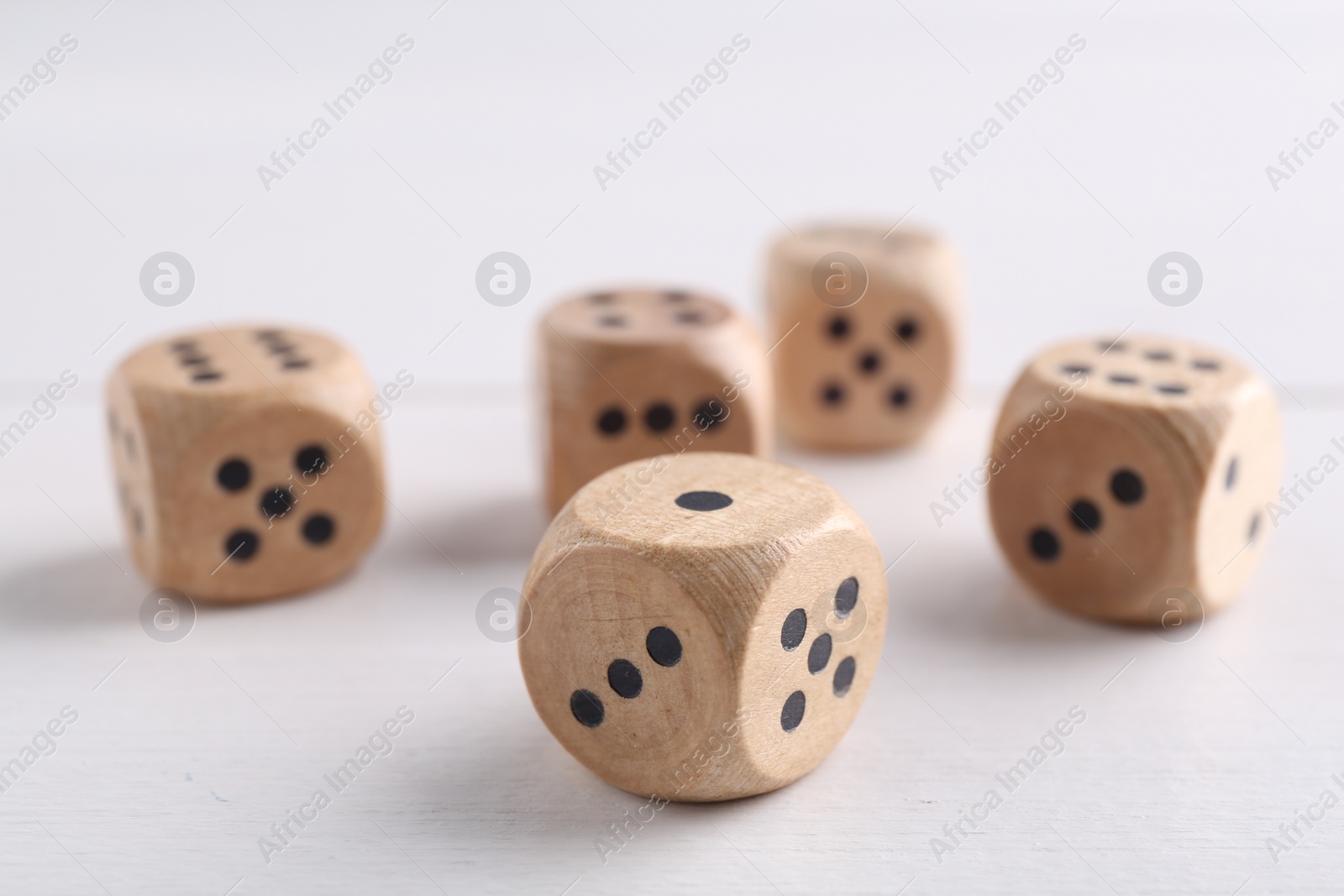 Photo of Many game dices on white wooden table, closeup