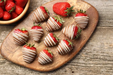 Photo of Delicious chocolate covered strawberries on wooden table, flat lay