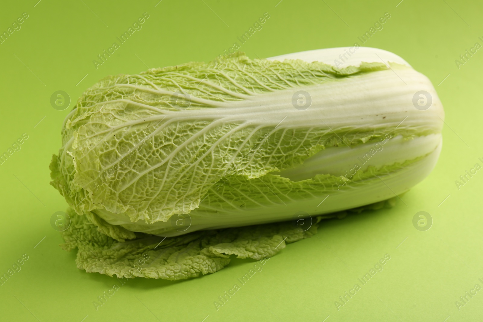 Photo of Fresh ripe Chinese cabbage on light green background, closeup