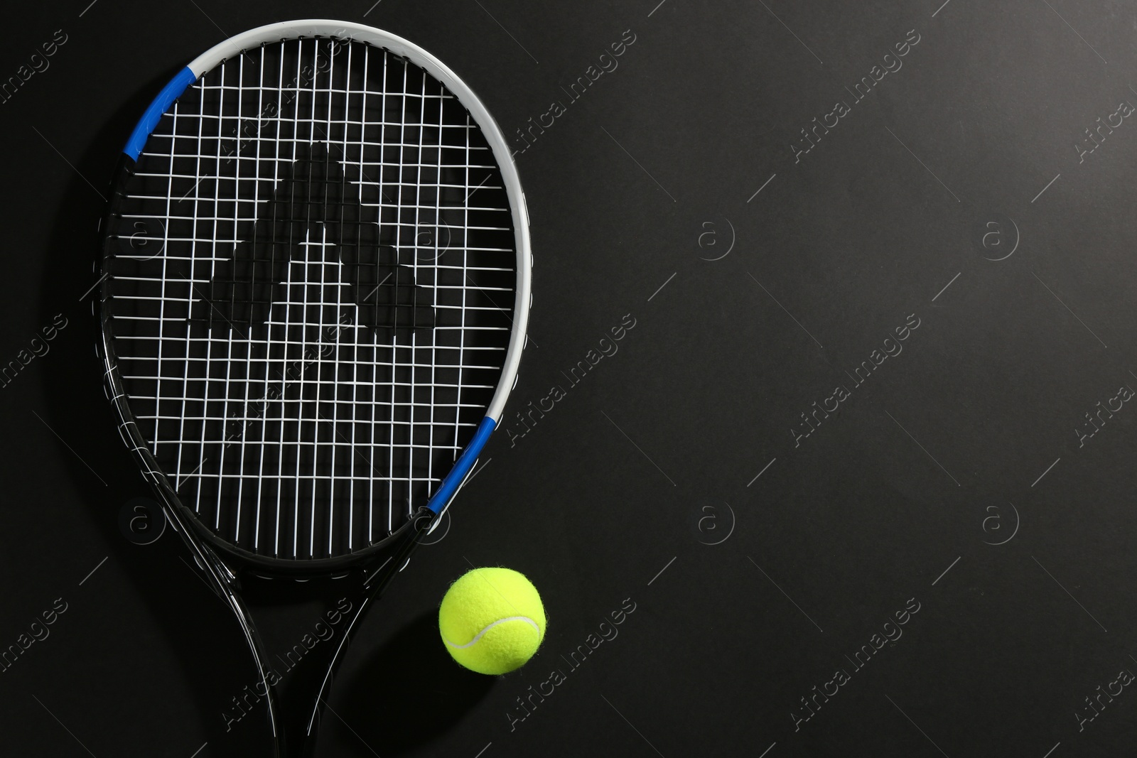 Photo of Tennis racket and ball on black background, flat lay. Space for text