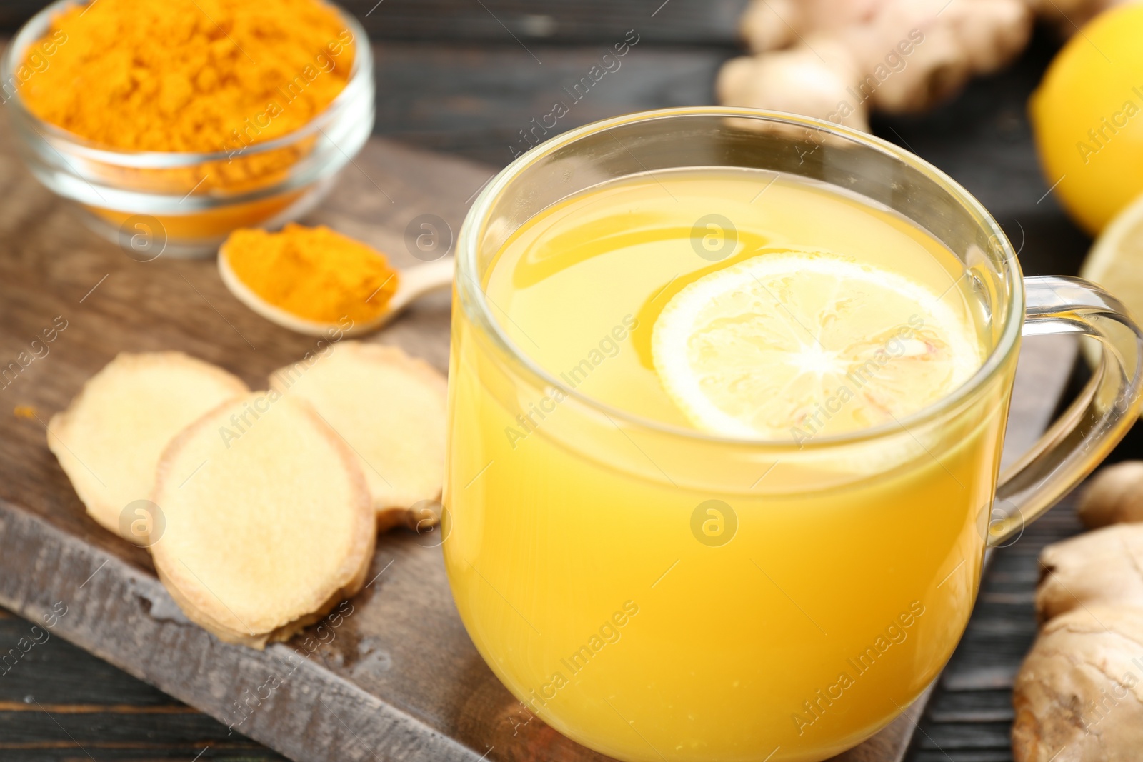 Photo of Immunity boosting drink with ginger, lemon and turmeric on table, closeup