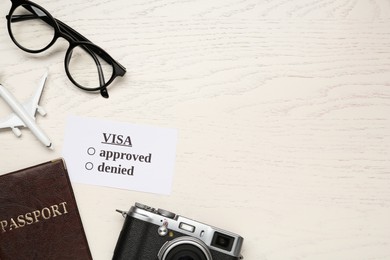 Flat lay composition with passport, toy plane and glasses on white wooden table, space for text. Visa receiving