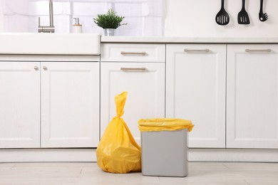 Photo of Plastic garbage bag and trash can in kitchen