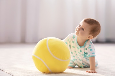 Cute baby playing with ball at home