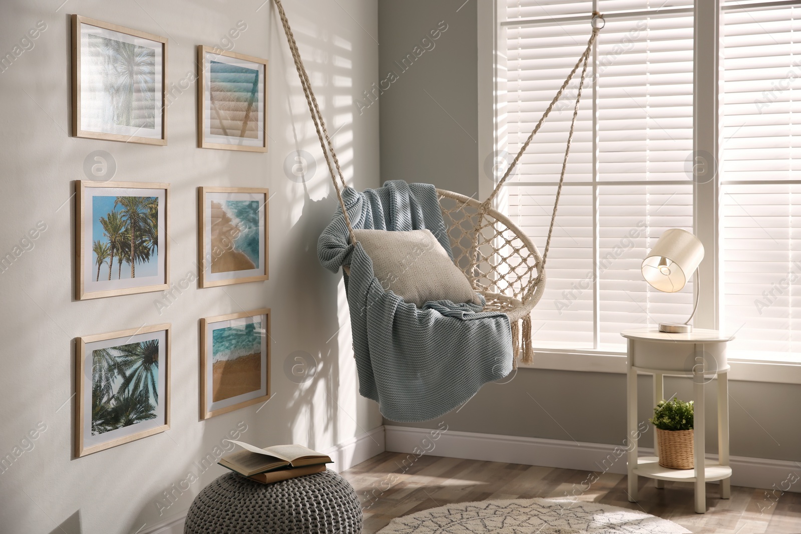 Photo of Stylish room interior with artworks and hanging chair