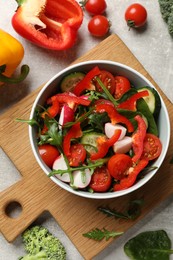 Tasty fresh vegetarian salad on light grey table, flat lay