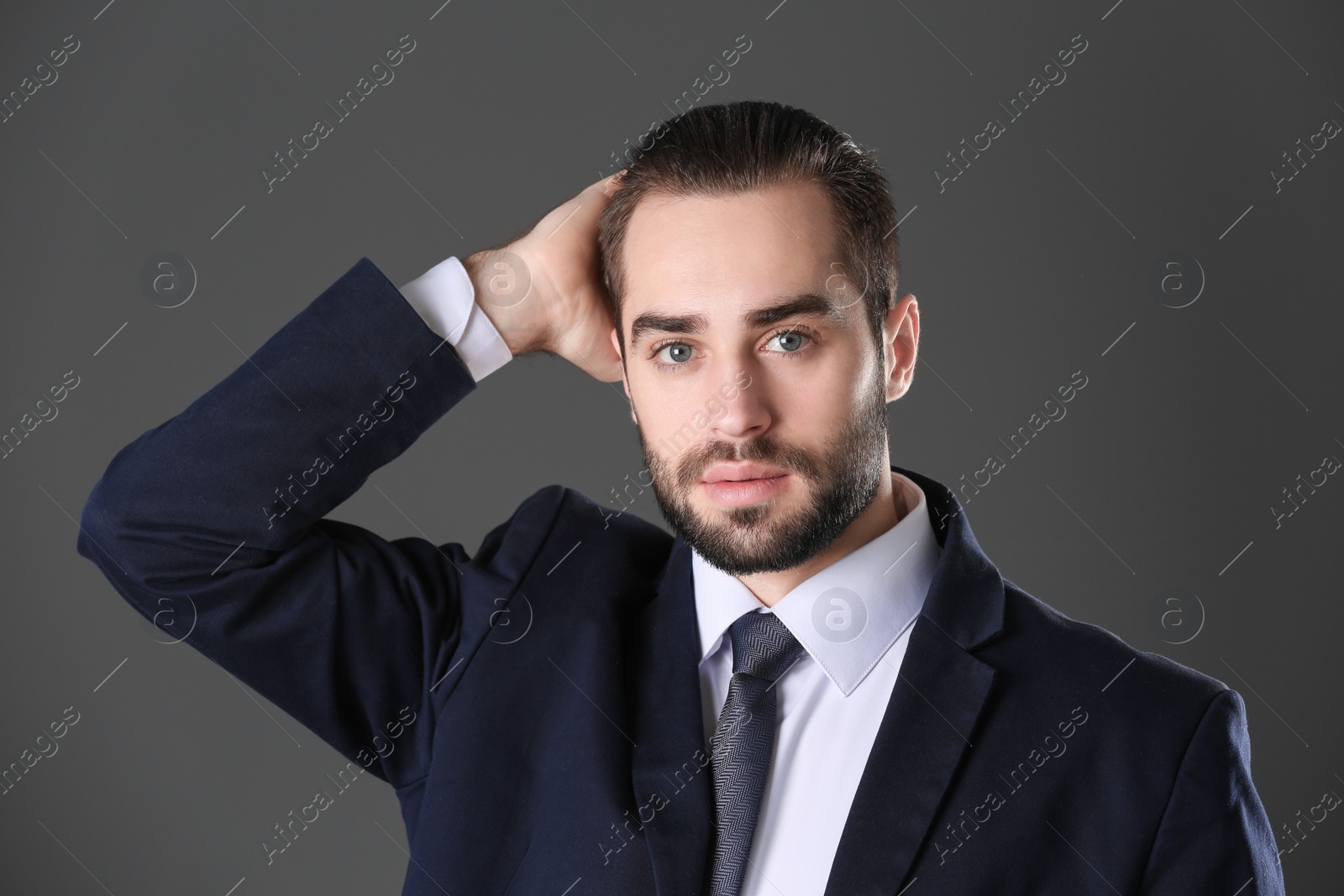 Photo of Portrait of young businessman with beautiful hair on grey background