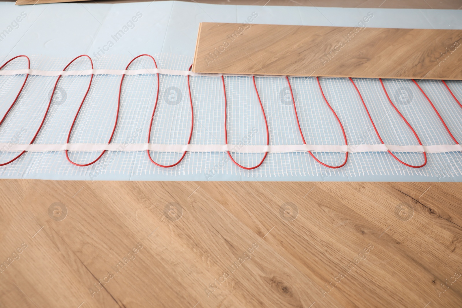 Photo of Installation of modern underfloor trace heating system indoors