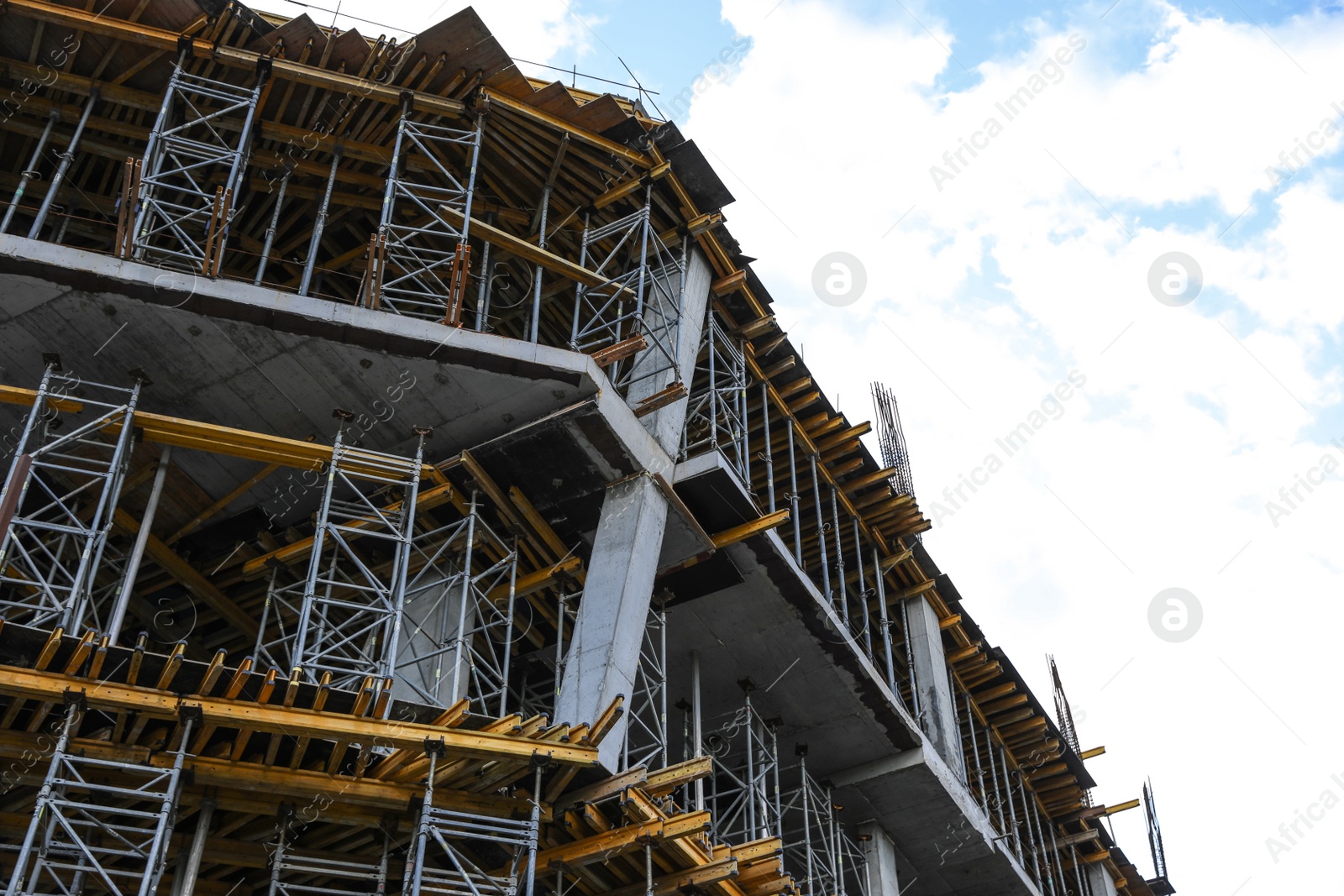 Photo of Unfinished building against blue sky. Construction safety rules