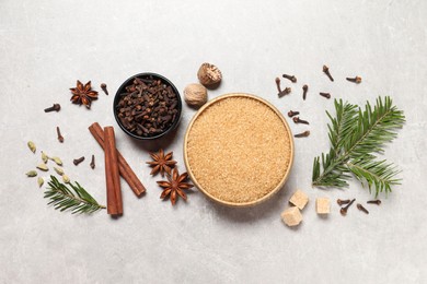 Photo of Different spices in bowls, nuts and fir branch on light gray textured table, flat lay