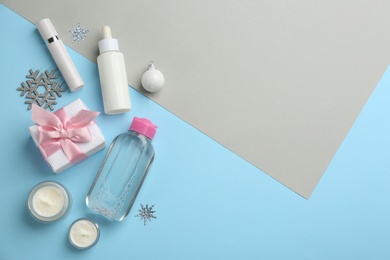 Photo of Flat lay composition with cosmetic products on light blue and grey background, space for text. Winter care