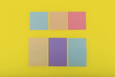 Photo of Colorful sticky notes on yellow background, flat lay