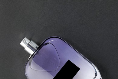 Photo of Luxury men`s perfume in bottle on black background, top view. Space for text