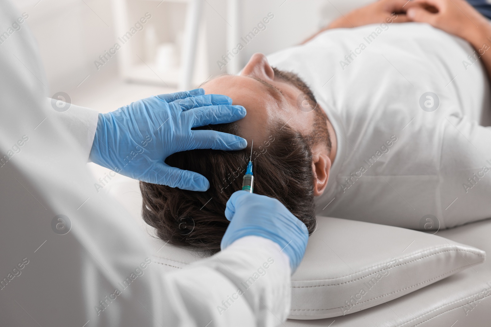 Photo of Trichologist giving injection to patient in clinic, closeup