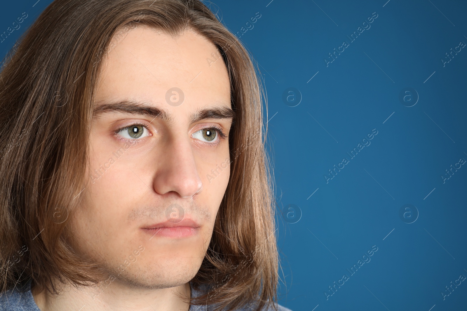 Photo of Portrait of young man on blue background, closeup