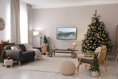 Photo of Modern TV set on light wall in room decorated for Christmas